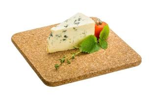 queijo azul na placa de madeira e fundo branco foto