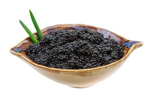 caviar preto em uma tigela no fundo branco foto