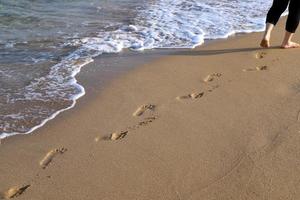 pegadas na areia nas margens do mar mediterrâneo. foto