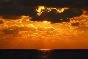 o sol se põe abaixo do horizonte no mar mediterrâneo no norte de israel. foto