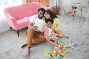 feliz família africana se divertindo em casa, amor familiar, pais e criança interna foto