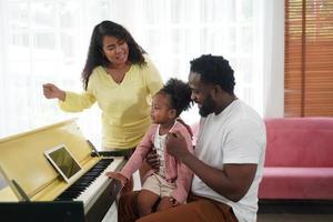 feliz família africana se divertindo em casa, amor familiar, pais e criança interna foto