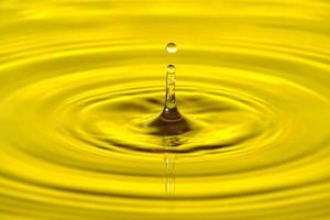 respingo gota de água com círculos de água divergentes, sobre fundo amarelo.