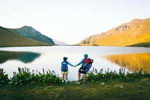 casal de caminhantes caucasianos fica feliz juntos ao ar livre pelo cênico lago black rock na geórgia. turista desfrutar de férias ativas na natureza em aventura de amor