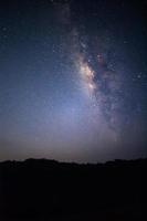 Via Láctea com estrelas e poeira espacial no universo, fotografia de longa exposição, com grãos. foto