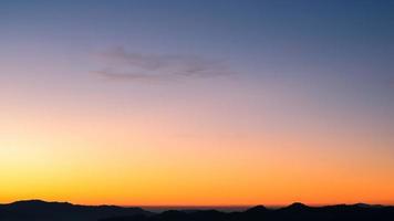 lindo céu de nuvem brilhante com luz para o fundo da religião do céu. o nascer e o crepúsculo ou o pôr do sol cloudscape são cores laranja e azul na natureza do verão. foto