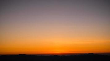 lindo céu de nuvem brilhante com luz para o fundo da religião do céu. o nascer e o crepúsculo ou o pôr do sol cloudscape são cores laranja e azul na natureza do verão. foto