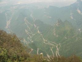 bela vista superior da estrada tongtian a estrada sinuosa 99 curvas estrada para o portão do céu, zhangjiagie, parque nacional da montanha tianmen, hunan, china foto