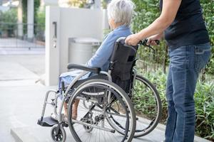 cuidador, ajuda e cuidado, idoso asiático ou idosa senhora paciente sentada em uma cadeira de rodas na enfermaria do hospital de enfermagem, conceito médico forte e saudável foto