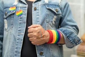 senhora asiática usando pulseiras de bandeira do arco-íris, símbolo do mês do orgulho LGBT, comemora anual em junho social de gays, lésbicas, bissexuais, transgêneros, direitos humanos. foto