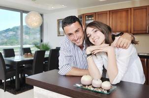 feliz casal jovem se diverte na cozinha moderna foto