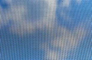 fundo do céu azul através de uma rede mosquiteira fina. foto