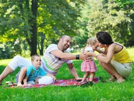 casal jovem feliz com seus filhos se divertir no parque foto