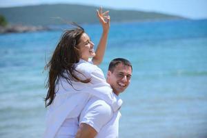 feliz casal jovem se divertir na praia foto