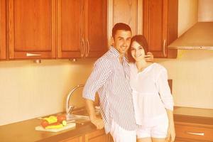 feliz casal jovem se diverte na cozinha moderna foto