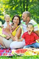 casal jovem feliz com seus filhos se divertir no parque foto