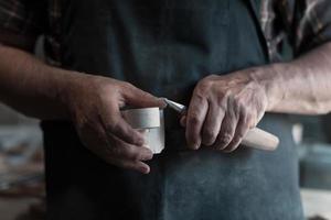 mãos esculpindo copo de madeira, trabalhando com cinzel close-up. oficina de madeira. processo de fabricação de utensílios de cozinha de madeira foto