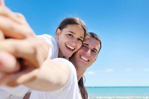 casal feliz se diverte na praia foto