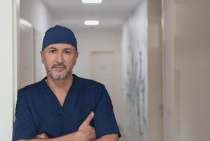 retrato de médico masculino maduro no corredor do hospital moderno ocupado. foto