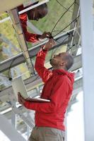 engenheiro usando laptop no campo de planta de painéis solares foto