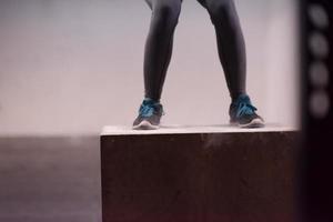 mulher negra está realizando saltos de caixa no ginásio foto