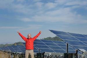 engenheiro usando laptop no campo de planta de painéis solares foto