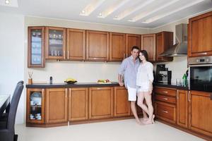 feliz casal jovem se diverte na cozinha moderna foto