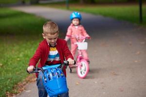 menino e menina com bicicleta foto