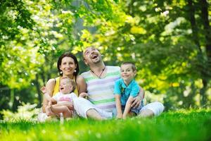 casal jovem feliz com seus filhos se divertir no parque foto