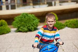 menino feliz aprendendo a andar de bicicleta foto