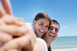 casal feliz se diverte na praia foto