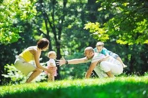 casal jovem feliz com seus filhos se divertir no parque foto