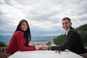 casal com máscara médica protetora tomando café em um restaurante foto