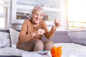 mulher sênior fazendo finanças em casa. mulher sênior feliz com calculadora e contando o dinheiro do euro em casa. negócios, poupança, seguro de anuidade, conceito de idade e pessoas foto