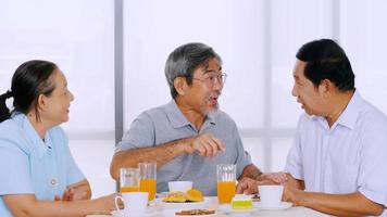 grupo de amigos seniores desfrutando de comer na mesa de jantar foto