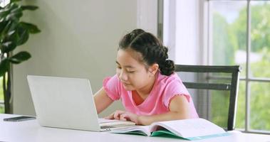 uma garota estudando ensino à distância on-line durante a quarentena em casa. foto