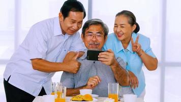 grupo de amigos seniores desfrutando de reunião na mesa de jantar foto