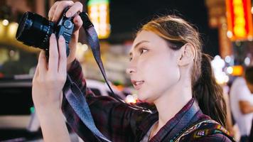 uma turista feminina gosta de tirar fotos da visão noturna da estrada yaowarat ou chinatown em bangkok, tailândia.