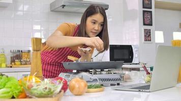 jovem mulher asiática cozinhando na cozinha em casa. foto