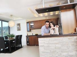 feliz casal jovem se diverte na cozinha moderna foto