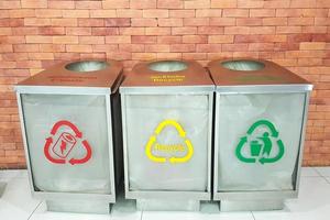 três lixeiras com cores e símbolos separados para cada categoria de lixo. foto