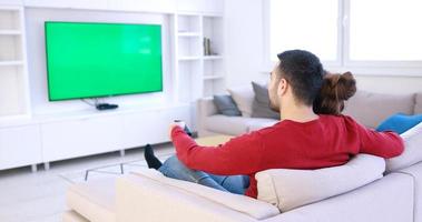 jovem casal no sofá assistindo televisão foto