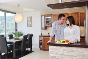feliz casal jovem se diverte na cozinha moderna foto