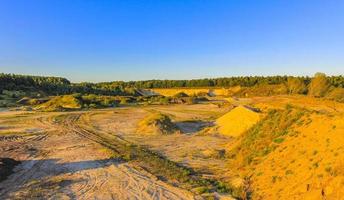 montanhas de areia escavadas e pilhas de entulho pedreira lago dragagem lagoa. foto