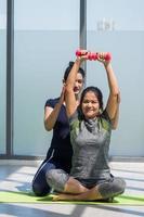 duas mulheres asiáticas fazendo ioga juntas em uma academia. foto