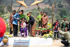 dieng, indonésia - 1 de agosto de 2015. festival de cultura de dieng, turistas seguem a procissão de dreadlocks durante o evento do festival de cultura de dieng em dieng, distrito de banjarnegara, java central foto