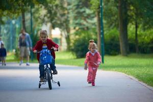 menino e menina com bicicleta foto