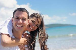 casal feliz se diverte na praia foto