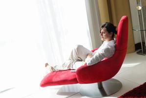 mulher jovem feliz relaxa em casa no sofá foto