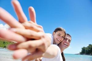 casal feliz se diverte na praia foto